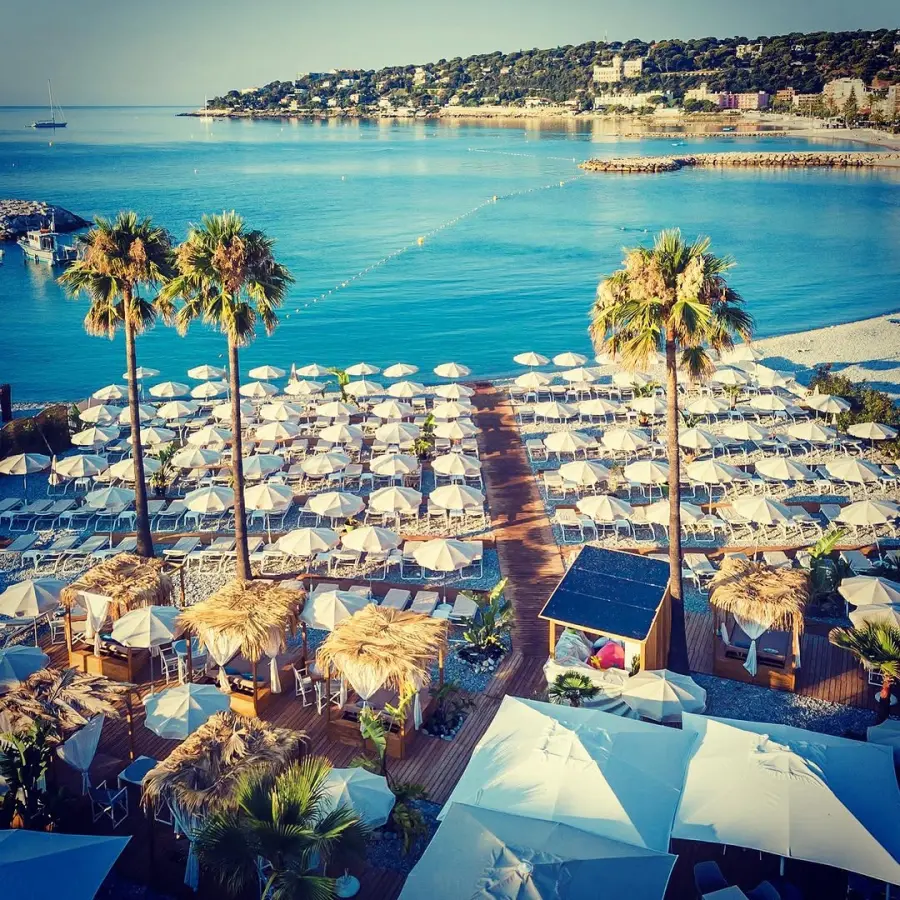 Plage privée, parasols et palmiers à Roquebrune-Cap-Martin, vue par drone